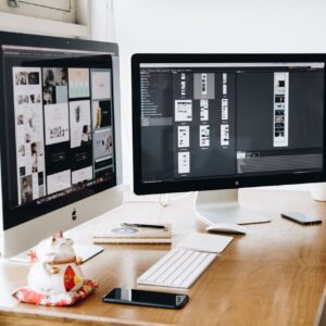 A well-organized design workspace with dual monitors and design software on display.